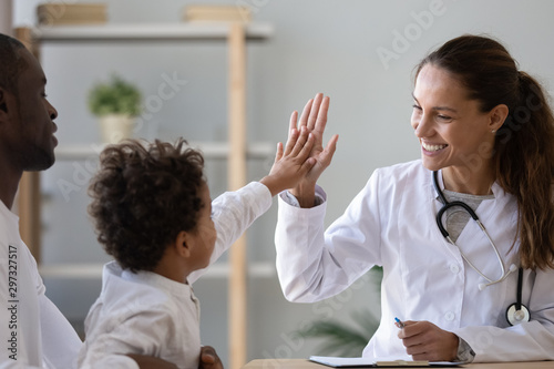 Smiling female doctor give high five to little biracial patient