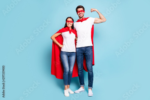 Full length body size view of nice attractive lovely content cheery sporty people hugging in red hero look guy showing arm muscle isolated on bright vivid shine vibrant blue turquoise background