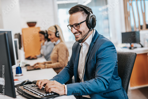 Handsome male customer service agent working in call center office as a telemarketer.