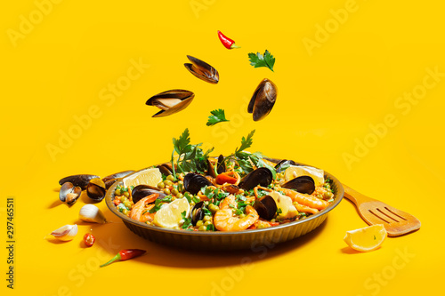 pan with spanish paella with seafood on a yellow background