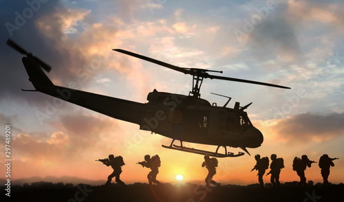 Military special force assault team helicopter drops during sunset