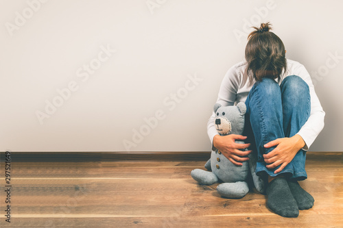 Prenatal loss concept - depressed woman holding teddy bear toy, copy space