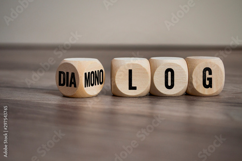 Cubes and dice on wooden background with the german words for dialogue and monologue - dialog und monolog
