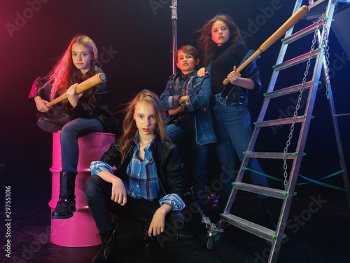 Rebel youth. Full length portrait of cocky children in stylish jeans and leather clothes. Concept of teenage riot, kids fashion, nonconformism and young energy. Modern lifestyle.