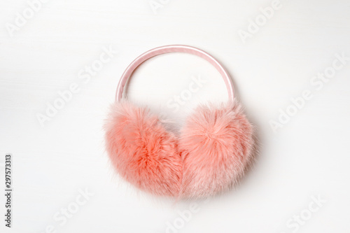 Warm fluffy pink ear muffs on a white background