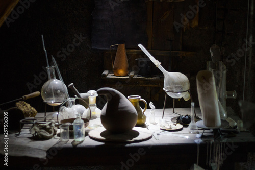 Set of alchemy bottles in laboratory of alchemist. Herb in old pots with dust on the glass surface.Alchemy symbol and objects. Poison and elixir in glass jar. Set of vessel, ampulla, flask,drink.....