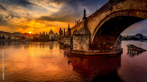 Charles bridge (Karluv most) at sunrise, scenic view of the Old town with Old Town Bridge Tower, colorful sky and historic medieval architecture, Prague, Czech Republic. Holidays in Prague