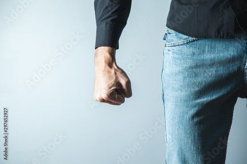 angry man fist on gray wall background