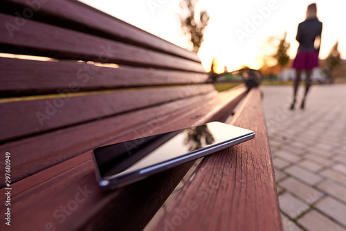 Forgotten smartphone on a park bench.