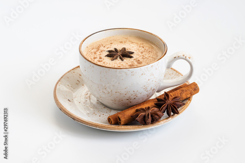 Indian Masala chai tea. Traditional Indian hot drink with milk and spices on white concrete background closeup.