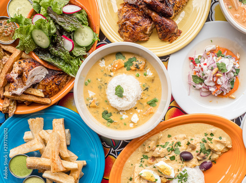 Full spread of Peruvian food on a colorful table. Roast chicken, ceviche, and yucca fries.