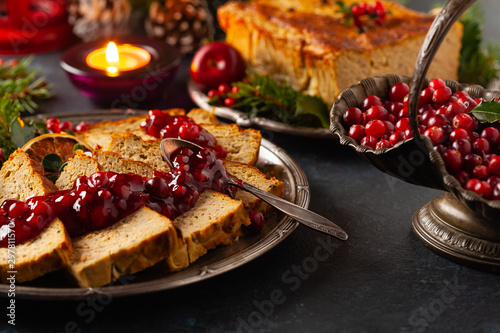 Delicious chicken and pork pate in Christmas decoration. Rustic style. Dark background, metal plates. Front view.