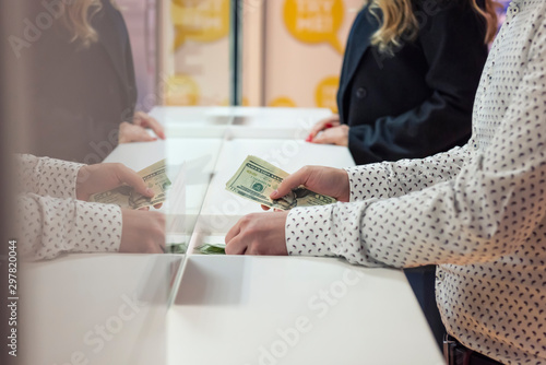 Money exchange concept / Male hand with money at cash desk. Currency exchange concept.