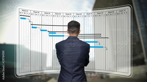 Businessman looks to Gantt chart, project schedule harmonogram work processes