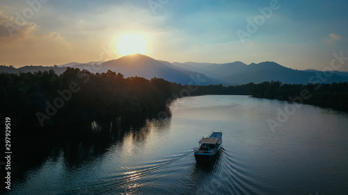 Beautiful Drone Shot of a Boat on the Prek Kampot River at Sunset during a River Cruise in Kampot, Cambodia.