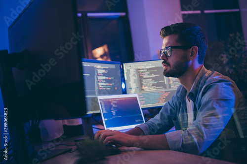 Profile side view portrait of his he nice attractive skilled focused serious guy writing script ai tech support devops creating digital solution front-end in dark room workplace station indoors