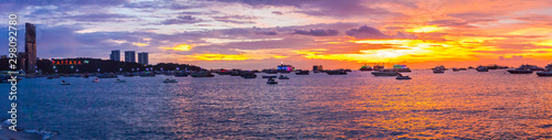 Panorama view of travel destination Pattaya Beach and PATTAYA lighting alphabet logo on sunset.