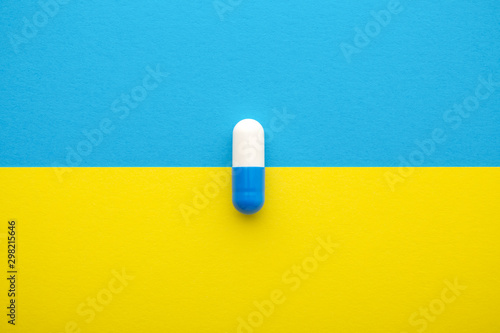 Medical pill on yellow blue background