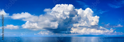 White cumulus clouds in blue sky over sea landscape, big cloud above ocean water panorama, horizon, beautiful tropical sunny summer day seascape panoramic view, cloudy weather, cloudscape, copy space