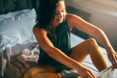Young woman in bedroom preparing herself for training