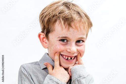 adorable boy playing with a fake toothless smile, isolated portrait