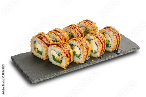 Sushi Rolls with Nishiki rice, nori, cheese, eel, seaweed salad, cucumber, sesame and Unagi sauce on black slate or stone shale surface isolated on white background.