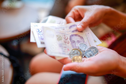 Hand hold a singapore dollar banknote ready for shopping, Singapore currency many value in shopping.