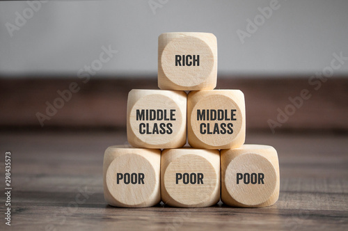 Pyramid made of cubes and dice with rich, middle class and poor on wooden background