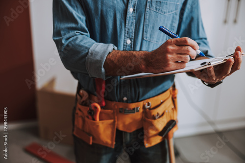 Construction worker writing on clipboard stock photo