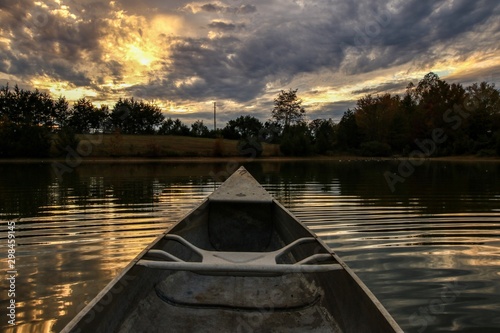 Point of view of a canoeist paddling on a serene country pond at sunset