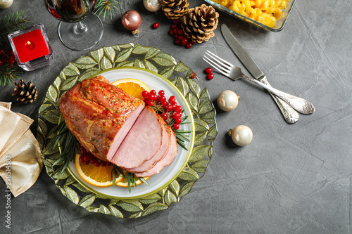 Flat lay composition with delicious ham served on grey table. Christmas dinner