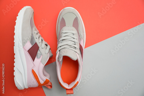 Stylish women's sneakers on color background, top view. Space for text