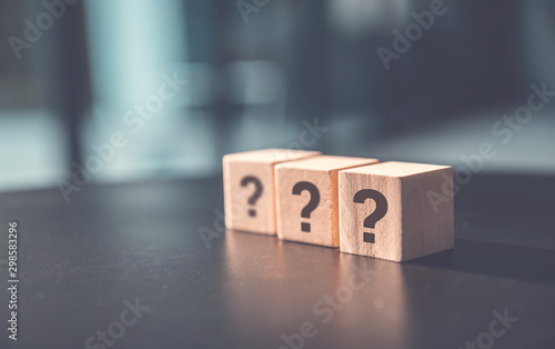 ? Questions Mark word in wooden cube block on table background. FAQ Answer, Q&A.