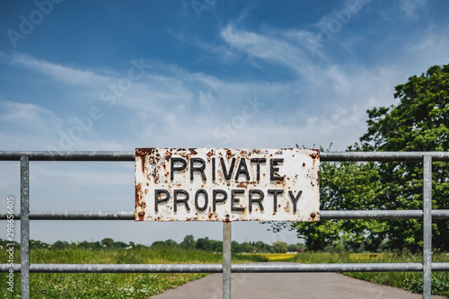 Private Property sign seen attached to a farm gate, warning members of the public not to enter the meadow as cattle roam free.