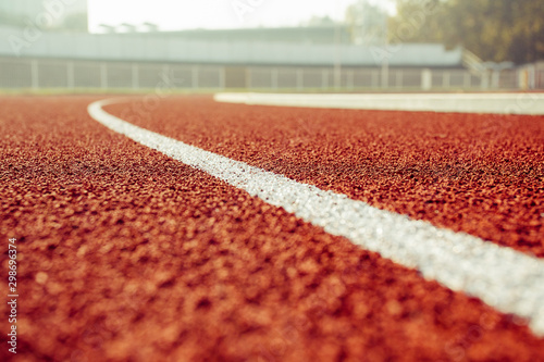 Empty red running track in stadium closeup