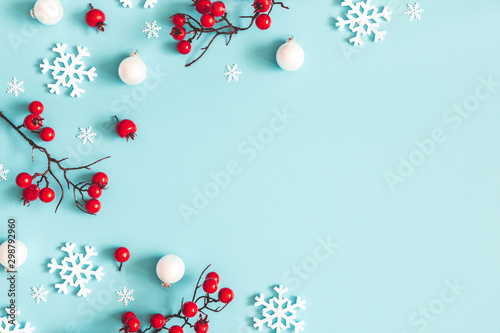 Christmas or winter composition. Snowflakes and red berries on blue background. Christmas, winter, new year concept. Flat lay, top view, copy space