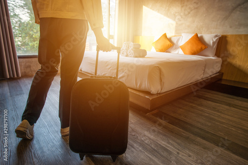 Tourist woman pulling her luggage to her hotel bedroom after check-in.