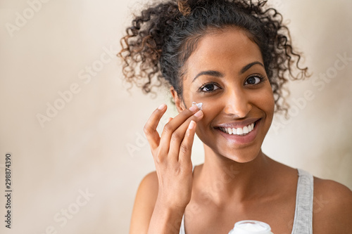 Beautiful girl applying face cream
