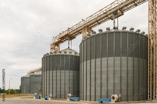 Modern elevator for storing grain against the sky. Grain drying complex, storage and transportation of grain. Large granary in the field. Agricultural industry