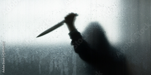 shadow of hand holding big sharp knife behind Frosted glass in the bathroom background.Robber,murderer or killer with knife.concept of scary crime scene of horror or thriller movies,Halloween theme