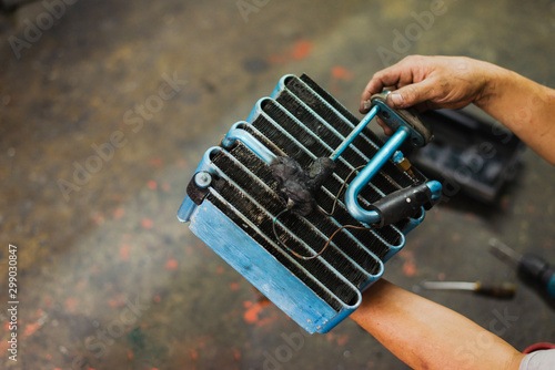 Car air conditioner evaporator coil close up.Auto mechanic worker fixing air condition system in car garage. Maintenance service, Repair checking vehicle engine tool.