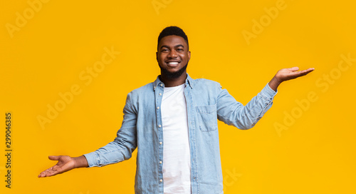 African guy comparing variants, making scales with his empty hands