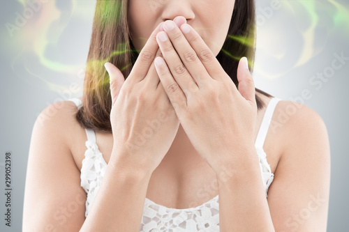 Asian woman in white wear close her mouth against gray background, Bad breath