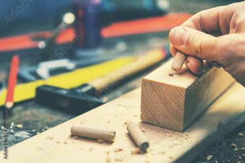 joiner putting dowel pin into a piece of wood