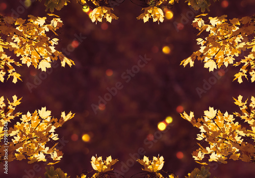 Decorative autumn frame decorated with branches with fall golden yellow maple leaves on background of orange autumnal foliage and shiny glowing bokeh, place for your text, Indian summer.