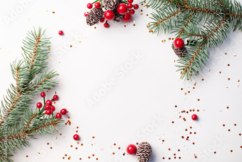 Christmas composition flatlay. Spruce branches, red berries on white background with space for text