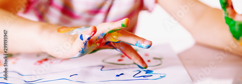 Close up young girl painting with colorful hands. Art, creativity and painting concept. Horizontal image.