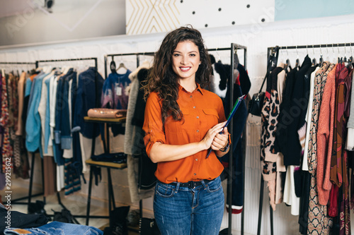 Beautiful female seller posing in exclusive boutique or store.