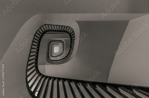 Gray scale low angle shot of a stairway going up surrounded by white walls