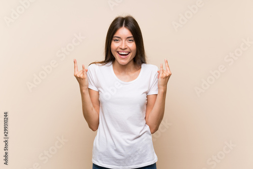 Pretty young girl over isolated background making rock gesture